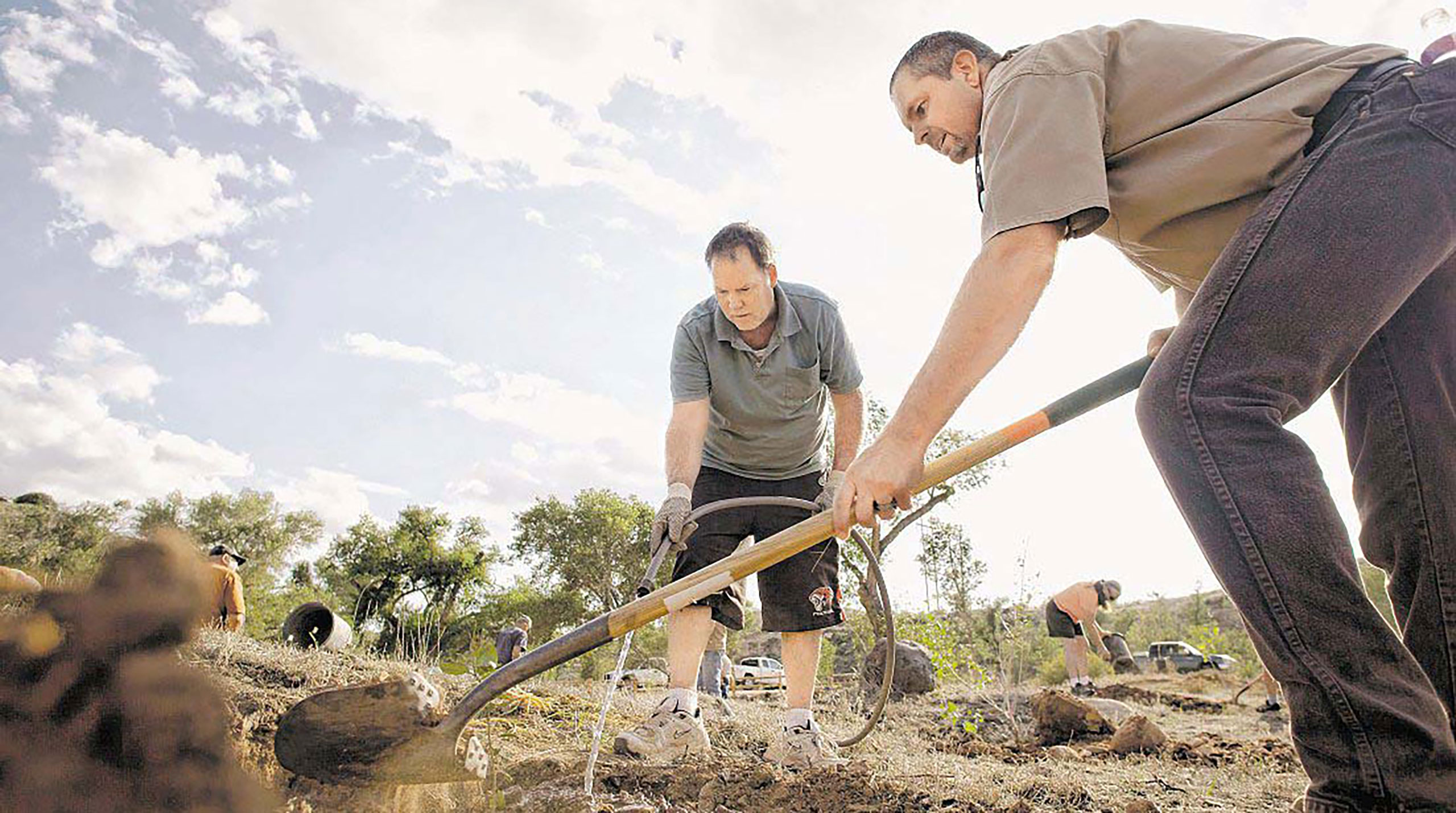 Utah State Parks employee Chris Haller, right, and LaVerkin resident Alan Olsen work on planting a tree at Confluence Park during the official opening and ribbon cutting celebration Monday for Confluence Park. Photos by Jud Burkett / The Spectrum & Daily News